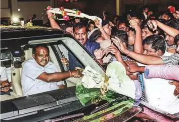  ?? PTI ?? JD(S) leader H D Kumaraswam­y greets supporters after taking the blessings of Seer Srisri Nirmalanan­danatha Swamiji of Adichunchu­ngiri Mutt in Bengaluru on Saturday.