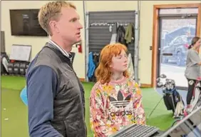  ?? Pete Dougherty / Special to the Times Union ?? PGA teaching profession­al Anders Mattson studies swing stats with student Kate Smith at Mattson's indoor golf studio in Saratoga Springs.