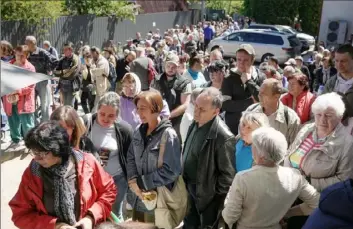  ?? Christophe­r Furlong/Getty Images ?? Residents wait in line Thursday for food and essential items at Irpin First Baptist Church in Irpin, Ukraine.