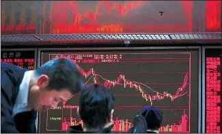  ?? (AP) ?? Chinese investors monitor stock prices near an electronic screen displaying composite index at a brokerage house in Beijing on Dec 20. Stocks were mixed in early trading in Asia on Friday after Wall Street posted more record
highs, extending the market’s gains for the week.