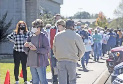  ?? STAFF PHOTO BY TROY STOLT ?? Collegedal­e residents line up at town hall for early voting for the Nov. 3 election on Saturday in Collegedal­e. More than 10% of registered voters in Tennessee have already voted, according to Secretary of State Tre Hargett. More than a million have voted in Georgia.