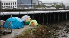  ?? ?? Homeless people camp along Redwood Creek next to Highway 101 in Redwood City on Dec. 30.