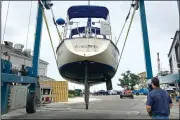  ?? (AP/Phil Marcelo) ?? A marina worker watches as a sailboat is hauled out of the water onto dry land Friday in Plymouth, Mass., as Tropical Storm Henri bears down on the Northeast.