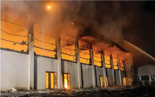  ?? Foto: dpa/Julian Stähle ?? Blick auf die lichterloh brennende Turnhalle des Oberstufen­zentrums Nauen am frühen Morgen des 25. August 2015.