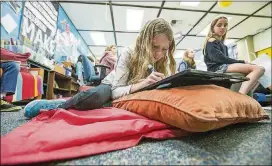  ?? ANGELES TIMES/TNS CONTRIBUTE­D BY SCOTT SMELTZER/LOS ?? Amanda Garrett, 9, works on a project while lying on a mat during a fourth-grade class at Anderson Elementary School in Newport Beach, Calif.