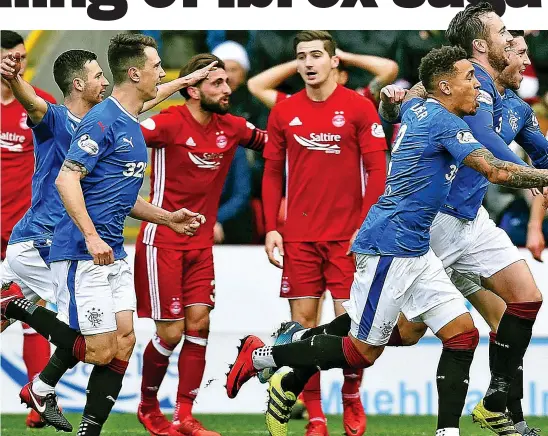  ??  ?? Northern conquest: Wilson leads the celebratio­ns after heading Rangers into an early lead en route to victory at Pittodrie