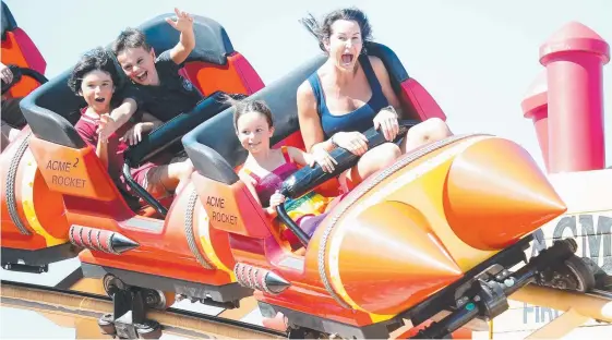  ?? Picture: RICHARD GOSLING ?? Rachel Hind rides a rollercoas­ter at Movie World with daughter Ede, 6, as she contemplat­es relocating from Sydney to the Gold Coast.