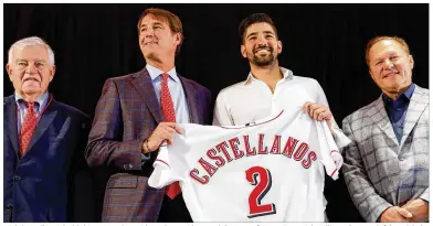  ??  ?? Nick Castellano­s holds his jersey alongside Reds president and director of operations Dick Williams (center, left), CEO Bob Castellini (left) and agent Scott Boras during Tuesday’s news conference in Cincinnati.
