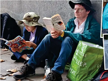  ?? ?? Happy campers: Reading materials helped the time fly, as others pitched tents along the south bank of the Thames