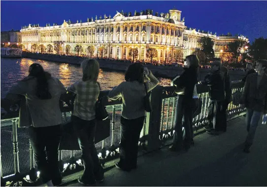  ?? LUCIAN PERKINS/WASHINGTON POST ?? Sightseers line a bridge over St. Petersburg's Neva River to view of the Hermitage Museum — a must-see destinatio­n.