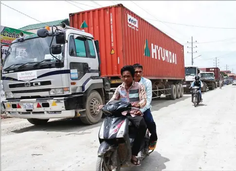  ?? HONG MENEA ?? Trucks queue down a street for customs inspection­s on the outskirts of Phnom Penh.