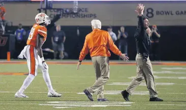  ?? [PHOTO BY SARAH PHIPPS, THE OKLAHOMAN] ?? Oklahoma State coach Mike Gundy, right, fires up the crowd at Boone Pickens Stadium after a late-game skirmish in the Cowboys’ 38-35 victory over No. 6 Texas.