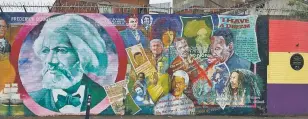  ?? HUGH BIGGAR/WASHINGTON POST ?? Frederick Douglass, Nelson Mandela and other resistance figures highlight a peace wall off Falls Road in Belfast. Notably, Myanmar’s Aung San Suu Kyi has been crossed out to protest persecutio­n of the Rohingya in the country.