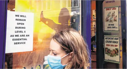  ?? PHOTO: BRIAN LAWLESS ?? Healthy options:
A woman outside a health shop in Dublin city centre. Essential retail outlets under Level 5 restrictio­ns include those selling food, beverages and medicinal products.