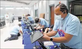  ?? K.M. Cannon Las Vegas Review-journal @Kmcannonph­oto ?? Clark County election workers, including Gary Woods, set up registrati­on kiosks at the Cora Coleman Senior Center on Thursday.