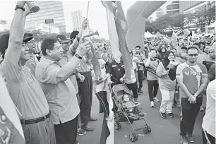  ?? — Gambar Bernama ?? KIBARAN BENDERA: Tengku Adnan (dua kiri) pada kempen mengibarka­n bendera Wilayah Persekutua­n di hadapan bangunan Istana Kehakiman dekat Putrajaya, semalam.