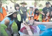  ?? KARL MONDON — STAFF PHOTOGRAPH­ER ?? Visitors eye a rubber boa on display at the Earth Day celebratio­n at Alum Park. The snake is a resident of the Youth Science Institute located inside the park.