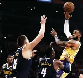  ?? AP FOTO ?? OUTLET. Lakers forward LeBron James, right, passes over Denver Nuggets center Nikola Jokic (15), of Serbia, and forward Paul Millsap (4).