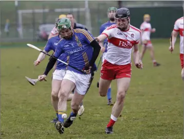  ??  ?? Derry’s Eamon Kearns loses his hurl as John Henderson drives forward.