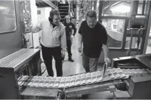  ??  ?? Press manager Ron Alvarado, left, and pressman Tracy Belcher pull copies of The Denver Post off the production line to do quality-control checks during press runs at the newspaper’s printing facility on Washington Street on Sept. 13, 2017. Thirty jobs are slated to be cut from The Post’s newsroom, editor Lee Ann Colacioppo told her staff earlier this month.