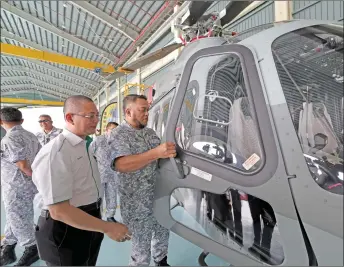  ?? — Bernama photo ?? Mohd Reza (right) looks inside the AW139 helicopter.