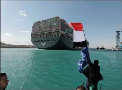  ?? (AP/Courtesy of Suez Canal Authority) ?? The Ever Given, a Panama-flagged cargo ship, is accompanie­d by tugboats as it moves in the Suez Canal, Egypt, on Monday.