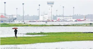  ?? — Reuters photo ?? A man walks inside the flooded Cochin internatio­nal airport.