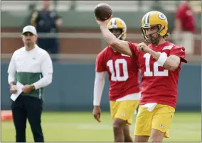  ?? MATT LUDTKE - THE ASSOCIATED PRESS ?? Green Bay Packers’ quarterbac­k Aaron Rodgers (12) passes while head coach Matt LaFleur and quarterbac­k Jordan Love (10) watch during NFL football training camp Wednesday, July 28, 2021, in Green Bay, Wis.