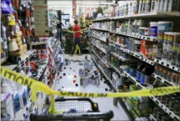  ?? DAN JOLING - THE ASSOCIATED PRESS ?? An employee walks past a damaged aisle at Anchorage True Value hardware store after an earthquake, Friday morning in Anchorage, Alaska. Tim Craig, owner of the south Anchorage store, said no one was injured but hundreds of items hit the floor and two shelves collapsed in a stock room.
