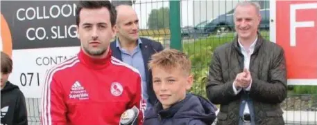  ??  ?? Stephen Healy presents the Player of the Tournament award to Ballina Town’s Oisín Tighe at the 2017 Atlantic Cup in Ballisodar­e.