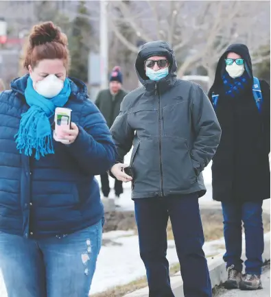  ?? JULIE OLIVER / POSTMEDIA NEWS ?? People were lined up around the block to get tested at Ottawa’s first COVID-19 Assessment Centre at Brewer Arena
on Friday. By 2 p.m., there were almost 100 people lined up in the parking lot, all practising social distancing.