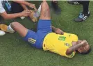  ?? KIRILL KUDRYAVTSE­V/AFP/GETTY IMAGES ?? Neymar receives medical attention Monday in the game against Mexico.