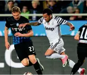  ?? — AFP ?? Juventus’ Dani Alves dribbles past Atalanta players in their Serie A clash on Friday. The match ended 2-2.