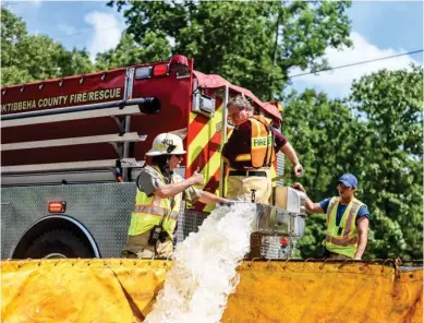  ?? (Photo by Logan Kirkland, SDN) ?? Sturgis Fire Department Chief Greg Wall helps direct volunteer firefighte­rs as they drop water into the dump tanks during the exercise last week.