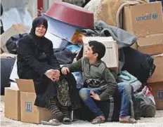  ?? AFP ?? ■ A boy who was evacuated from the rebel-held town of Harasta in Eastern Ghouta looks at a woman in a camp for displaced people in Maaret Al Ikhwan, in Idlib, yesterday.