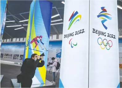  ?? KEVIN FRAYER / GETTY IMAGES ?? A journalist last week takes pictures of a display at the exhibition centre for the Beijing 2022 Winter Olympics.