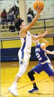  ??  ?? Enrique Rubi (left) goes in for a layup as Hutson Adams (Warrior 3) tries for a block. The Bulldogs got their first conference win of 2021.