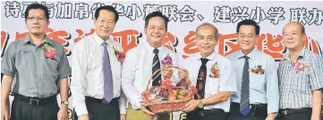  ??  ?? So (third right) hands over a basket of fruits to Goh for sponsoring a speech contest and a calligraph­y competitio­n.