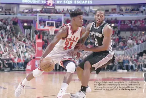  ?? — USA Today Sports ?? Chicago Bulls forward Jimmy Butler (21) dribbles the ball against San Antonio Spurs forward Kawhi Leonard (2) during the second half at the United Center. Chicago defeated San Antonio 95-91.