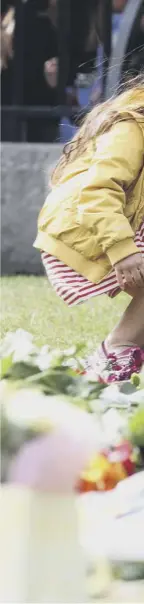  ??  ?? A girl lays flowers outside Windsor C