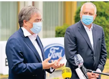  ?? FOTO: DPA ?? Ministerpr­äsident Armin Laschet und Gunnar Herrmann, Chef der Ford-Werke GmbH, äußern sich zum Hochfahren der Fabrik in Köln. Hier kommen 7500 Mitarbeite­r aus der Kurzarbeit.