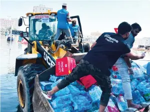  ?? — SUPPLIED PHOTO ?? Essential supplies being loaded on to a wheel loader for quick delivery to flood-hit residents of Ajman.