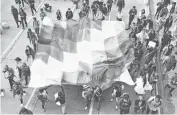  ?? Foto: AP ?? Miembros de la Guardia Indígena y estudiante­s marchan con la bandera wiphala. /