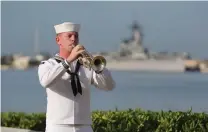  ?? Associated Press ?? A U.S. Navy sailor plays taps Monday in front of the USS Missouri during a ceremony to mark the anniversar­y of the attack on Pearl Harbor in Pearl Harbor, Hawaii.