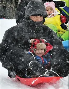  ?? CHRIS CHRISTO — BOSTON HERALD ?? Eric Bui and his year old son Enzo enjoy sliding on the fresh snow at Quinsigamo­nd Community College in Worcester.