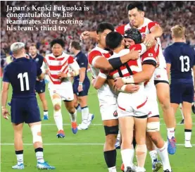  ??  ?? Japan’s Kenki Fukuoka is congratula­ted by his teammates after scoring his team’s third try