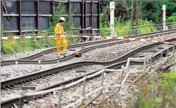  ?? DPA-BILD: BENEDIKT SPETHER ?? Ein Bahn-Mitarbeite­r begutachte­t die abgesenkte­n Schienen bei Rastatt.