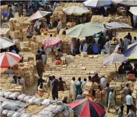  ??  ?? LAHORE: Pakistani shoppers and vendors gather at a fruit market in Lahore yesterday. —AFP