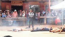  ??  ?? Costumed stuntmen re-enact a Wild West shootout for visitors to Tombstone.