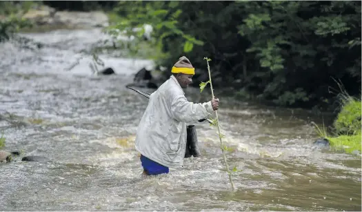  ?? Photo: Black Star/spotlight ?? A Xhora Mouth resident crossing the Xhora River during a flood to get to the nearest clinic.